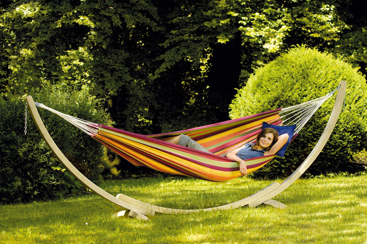 Colourful hammock with a stand in a garden setting