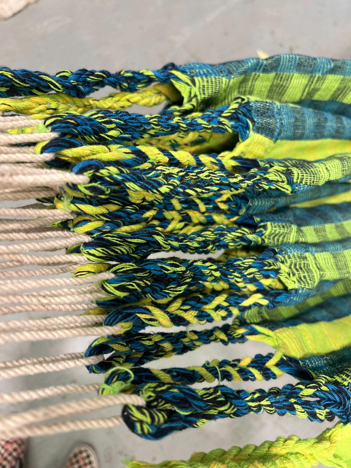 Close-up of colourful woven hammock with blue and green patterns.