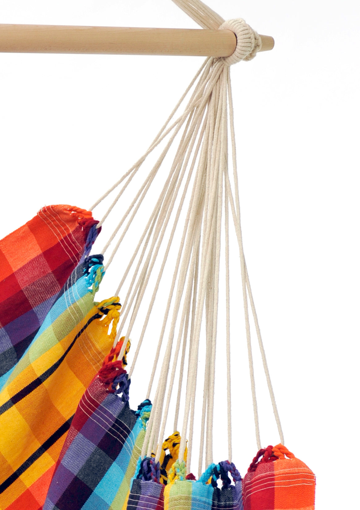 Colourful plaid hammock hanging from a wooden rod on a white background