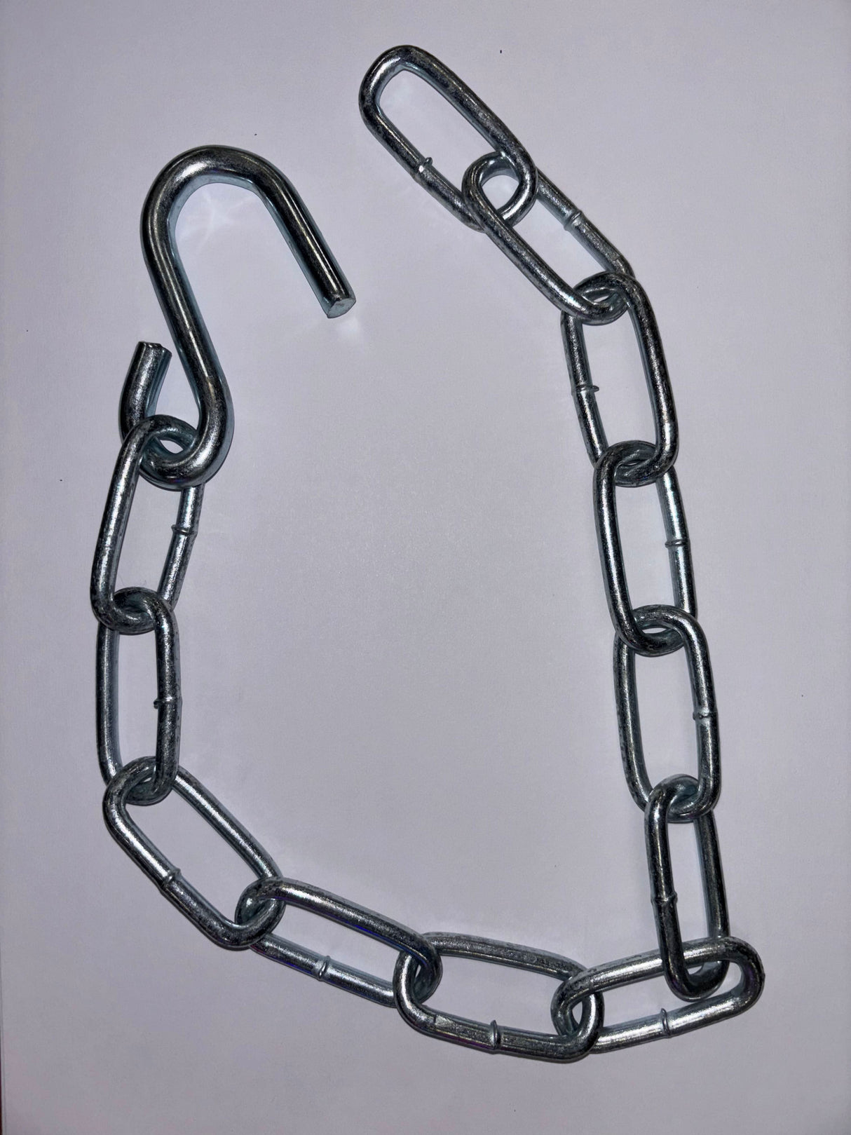 Metal chain with a hook on a grey background