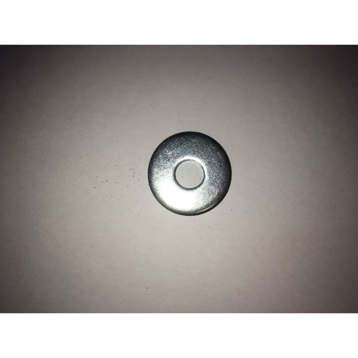 Metal washer on a beige background