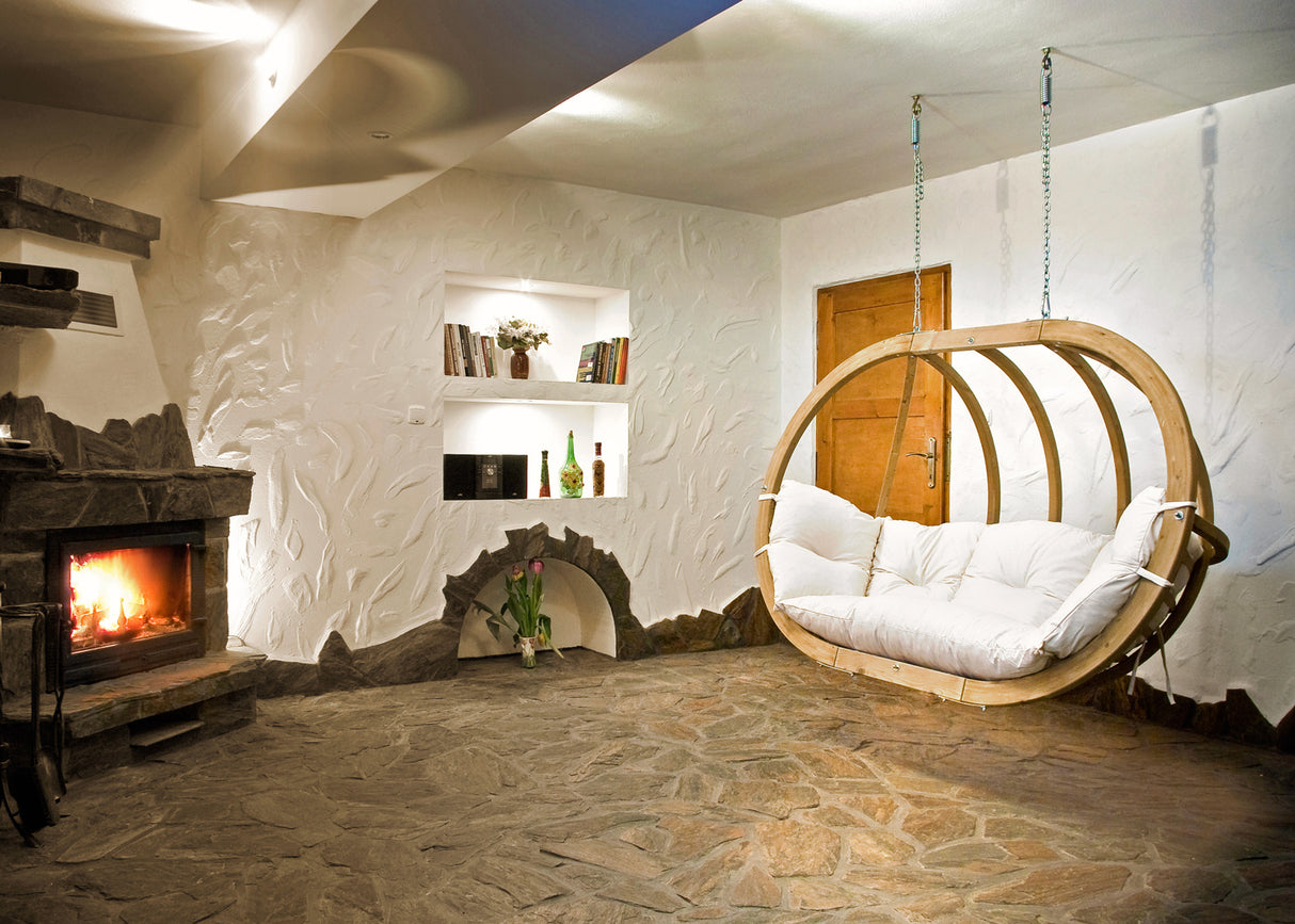 Cosy living room with a fireplace, bookshelf, and hanging wooden chair.