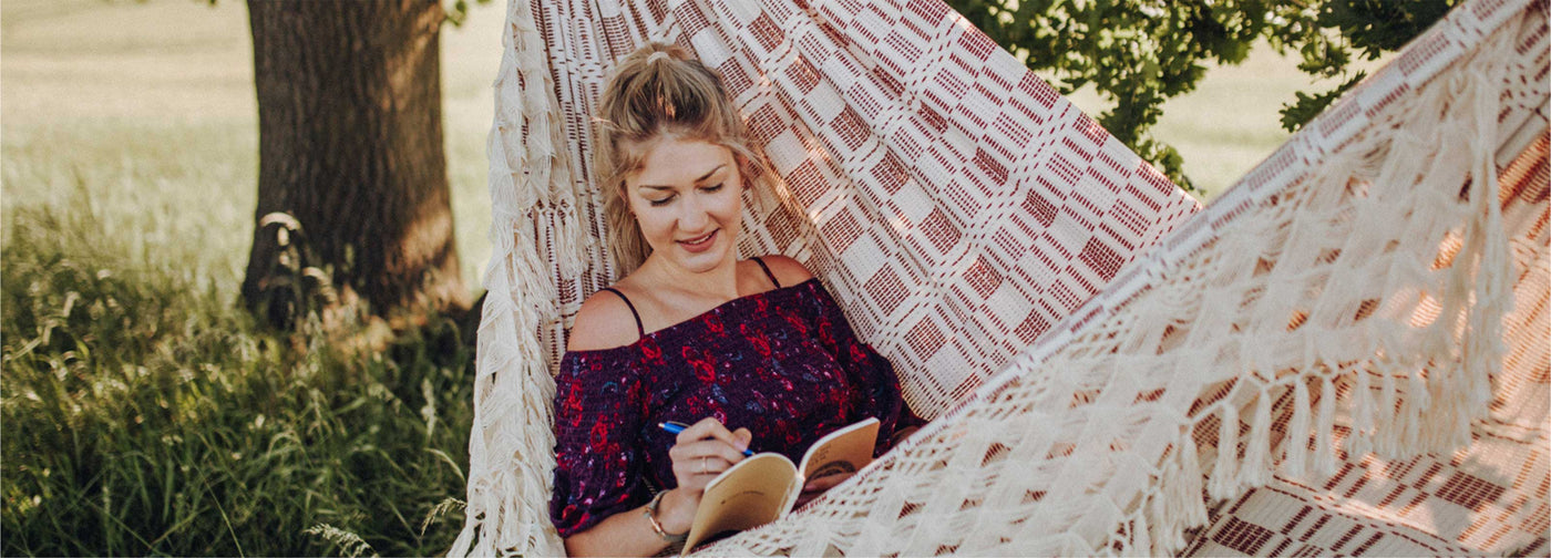 Woman reading a book in a hammock outdoors