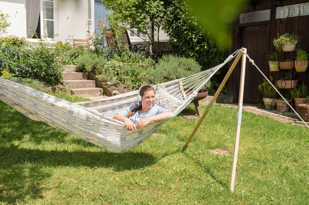 Person relaxing in a hammock in a garden setting