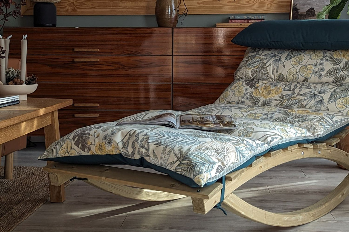 Wooden rocking chair with floral cushion in a room with wooden furniture and decor.