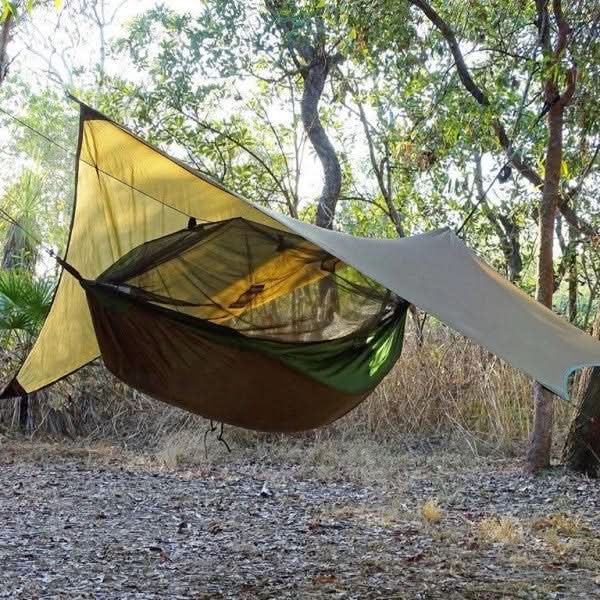 Camping hammock with canopy in a forest setting