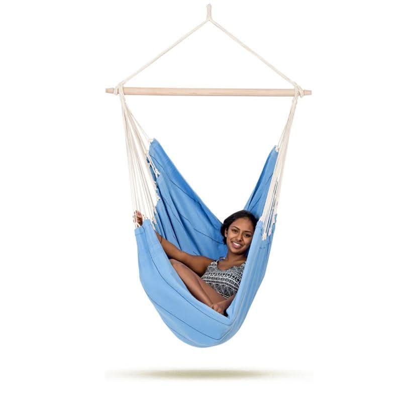Woman sitting in a blue hammock chair on a white background