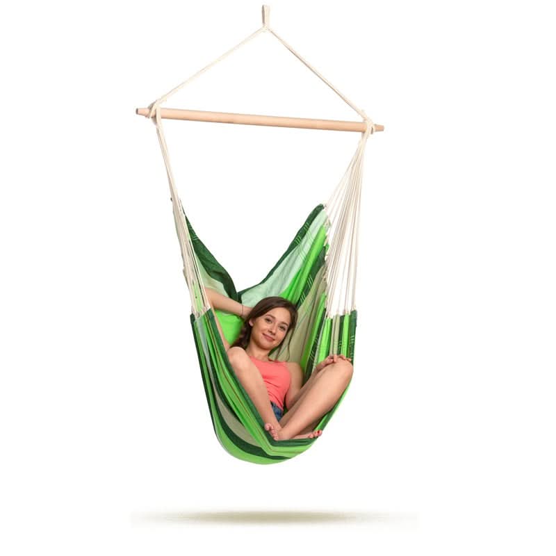 Person sitting in a green and white hammock chair on a white background