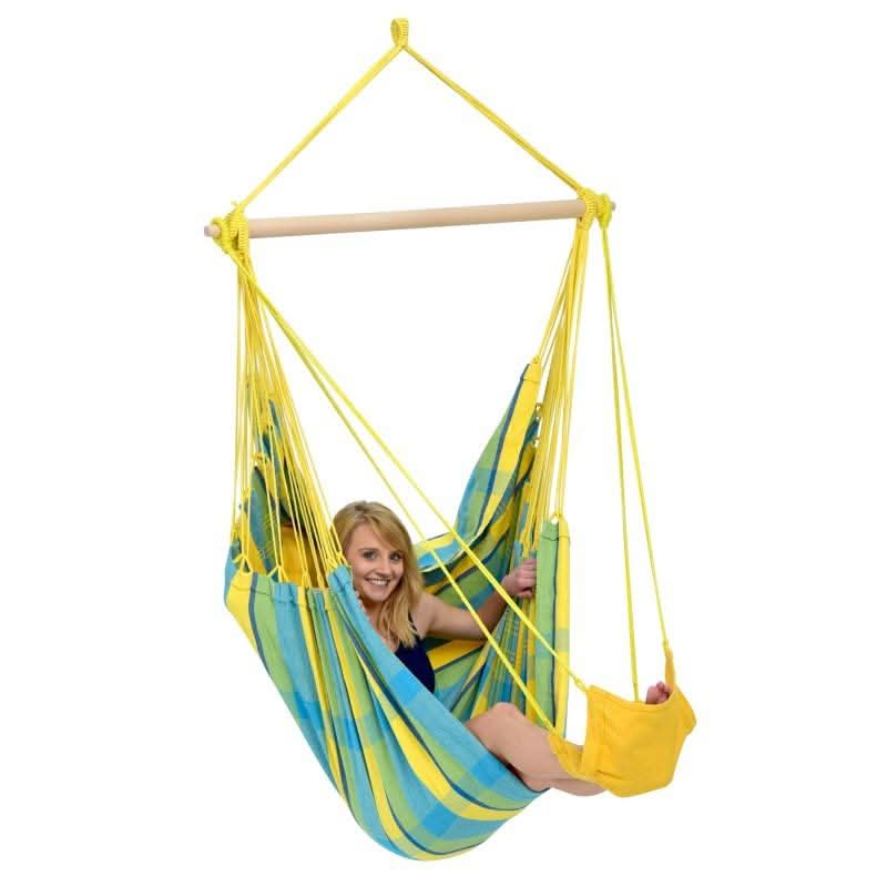Woman sitting in a yellow and blue hammock chair on a white background