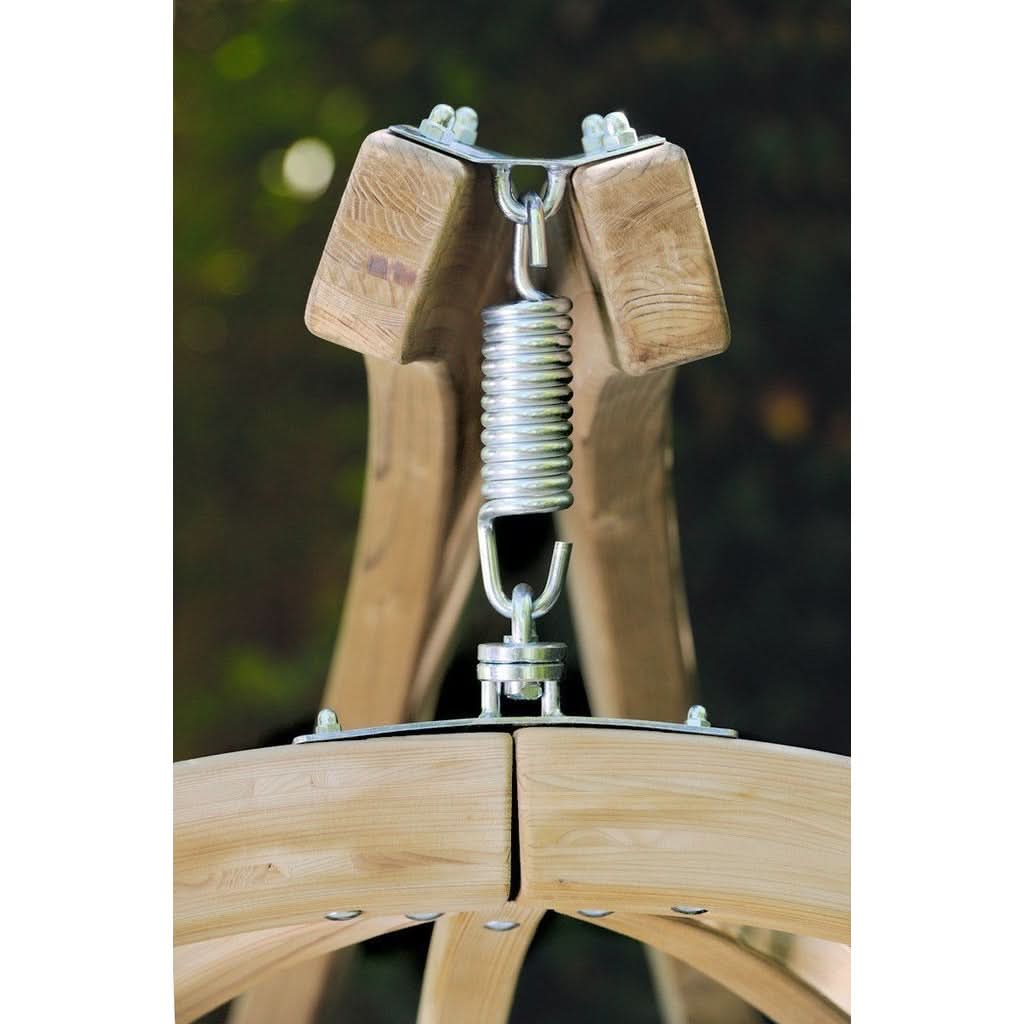 Wooden swing set with metal spring mechanism against a blurred green background