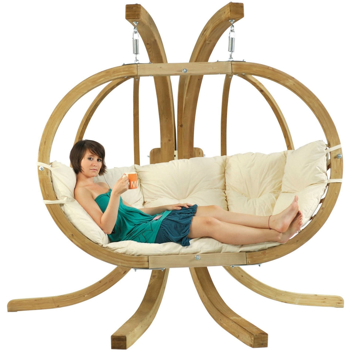 Person relaxing in a wooden hanging chair with beige cushions on a white background