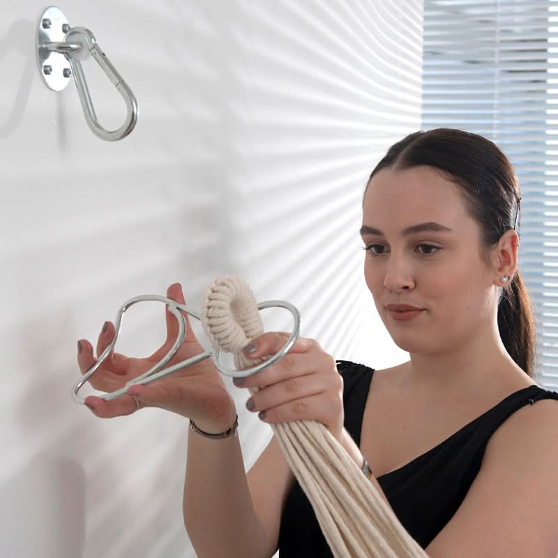 Woman holding a white hammock with a hook on a white background