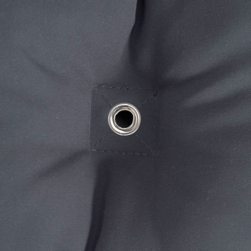 Close-up of a dark grey fabric with a grommet hole.