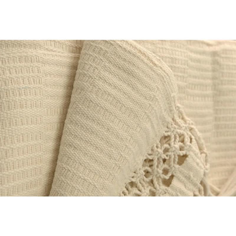 Close-up of beige fabric with a textured pattern and floral lace detail.