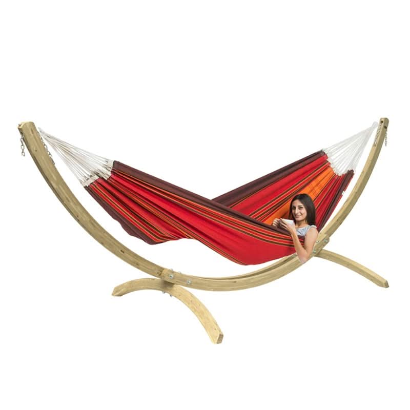 Red and orange striped hammock on a wooden stand with a person sitting inside.