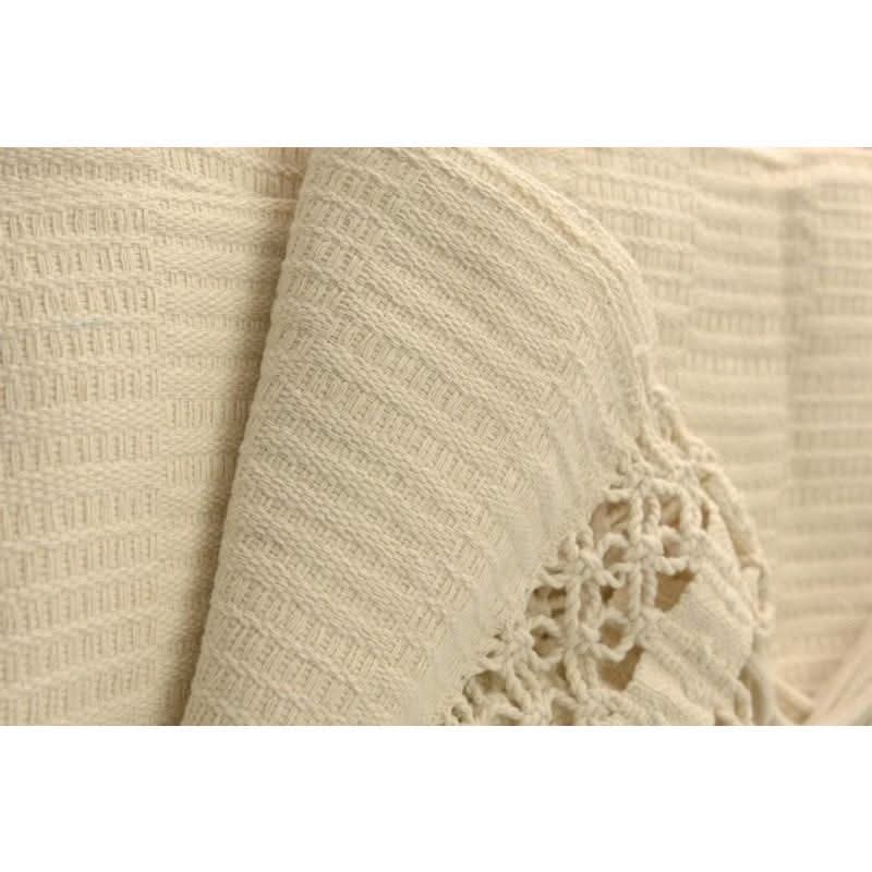 Close-up of beige fabric with a textured pattern and floral lace trim.