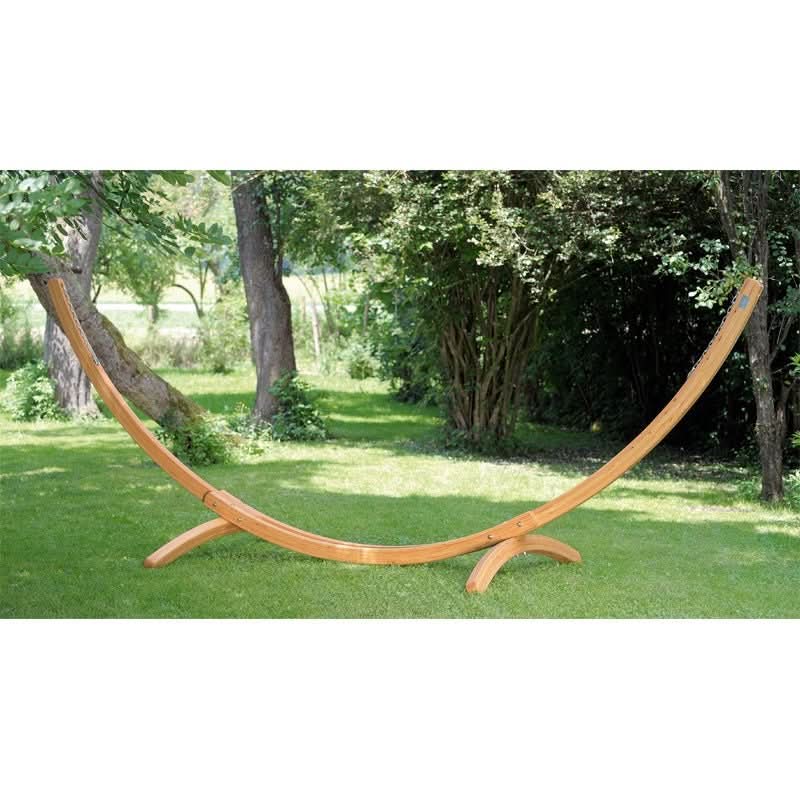 Wooden hammock stand in a garden setting with trees and grass.