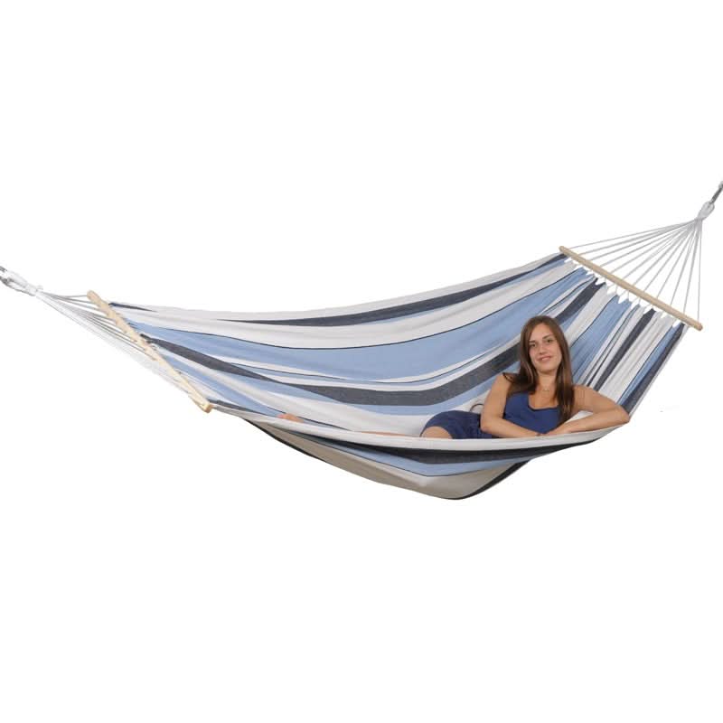 Woman sitting in a striped hammock on a white background
