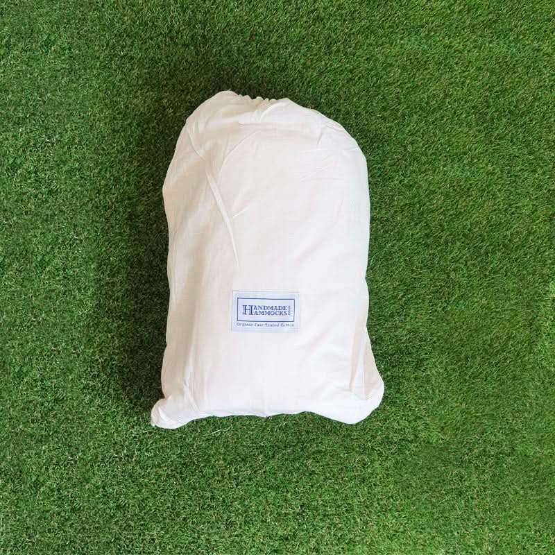 White drawstring bag with a label on a green grass background