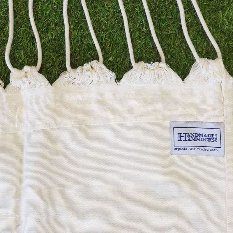 White drawstring bags with a 'Handmade Hammocks' label on grass