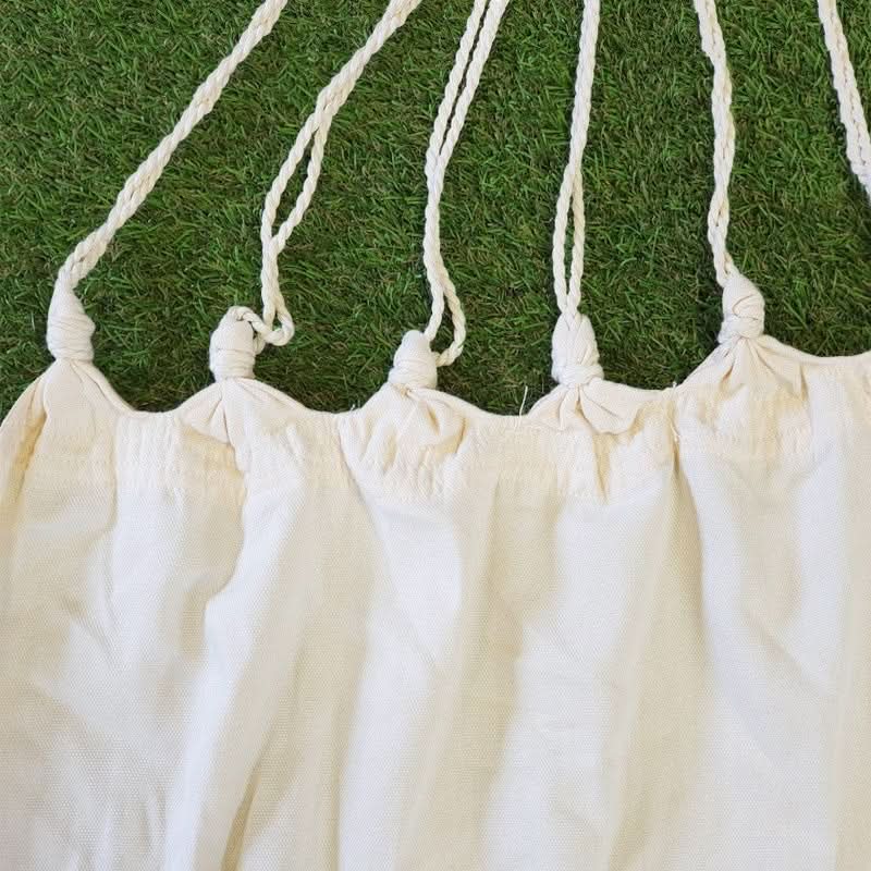 White fabric with string ties on a grass background
