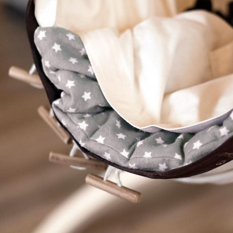 Grey cushion with a white star pattern on a wooden chair