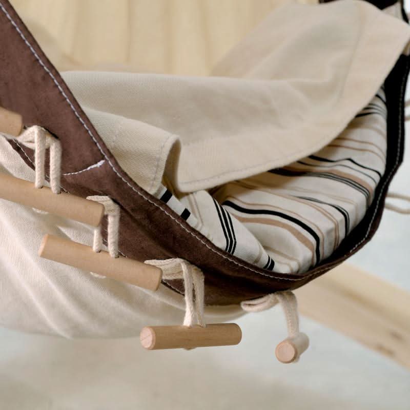 Close-up of a hammock with wooden bars and striped fabric lining.