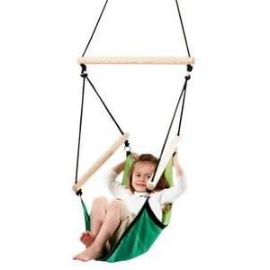 Child sitting in a green swing with a white background
