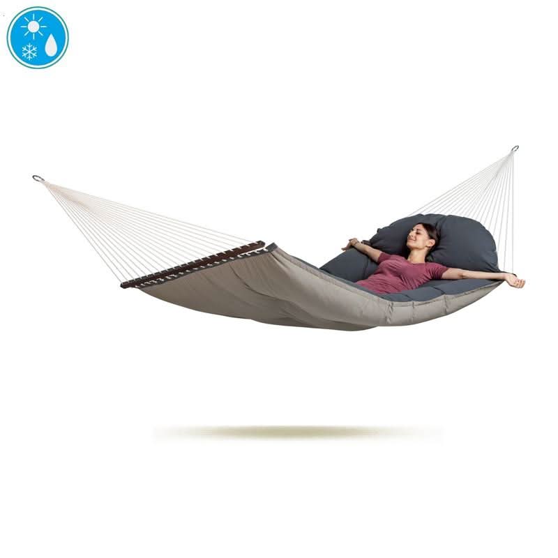 Person lying in a grey hammock with a white rope on a white background