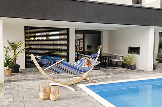 A woman sat in her hammock and a stand by the pool