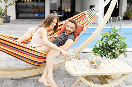 A man and woman sat in a vibrant Paradiso Tropical Hammock