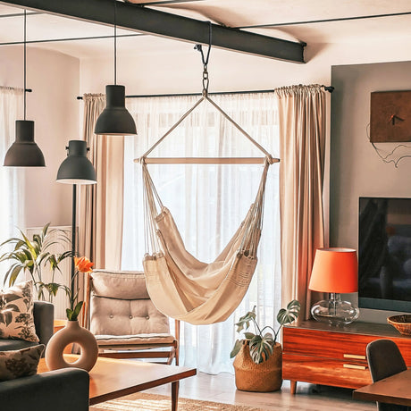 Living room with a beige hammock chair, plants, and modern decor.