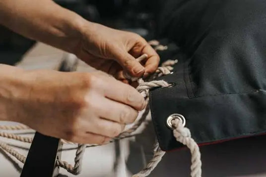 Close-up of hands tying a rope to a bag
