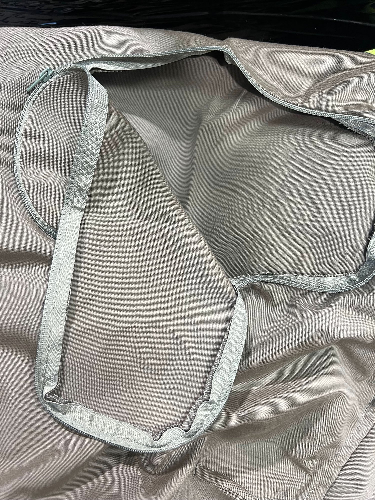 Close-up of a grey garment with a clear plastic cover on a dark background