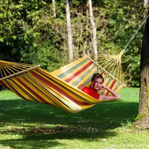 Person relaxing in a colorful hammock in a garden setting