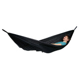A person lying in a black hammock against a plain white background.