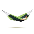 Person lying in a green and navy hammock on a white background