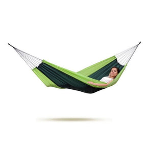Person lying in a green and navy hammock on a white background