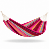 A striped fabric hammock suspended between two off-white ropes, featuring bold stripes of magenta pink, dark red, yellow, and light blue on a clean white background.