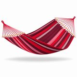 A striped fabric hammock with red, burgundy, and pink bands, suspended between two light wood spreader bars on a white background.