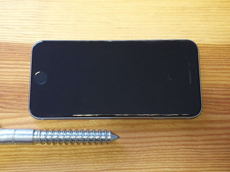 Smartphone on a wooden surface with a pen for scale
