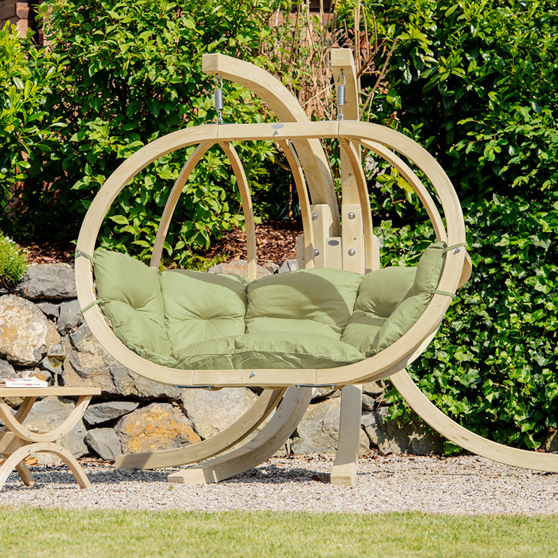 Globo Royal Oliva Double Seater Hanging Chair On A Stand Next To A Tavolino Table. 