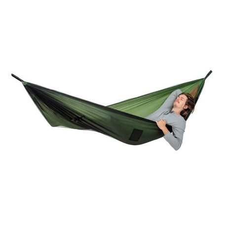 Person relaxing in a green hammock on a white background