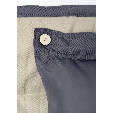 Close-up of a button on a piece of clothing with a beige and grey colour scheme.