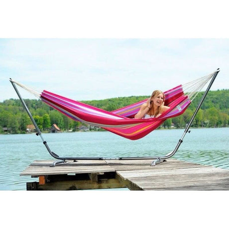 Woman relaxing in a colourful hammock on a dock by a lake