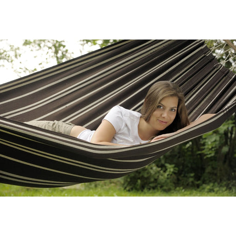 Woman lying in a striped hammock outdoors