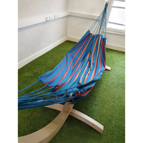 Blue and red striped hammock on a stand indoors with green carpet.