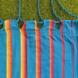 Colourful striped hammock with blue straps on the  grass