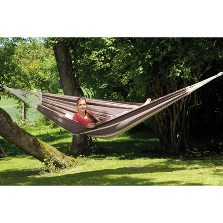 Person relaxing in a hammock surrounded by greenery