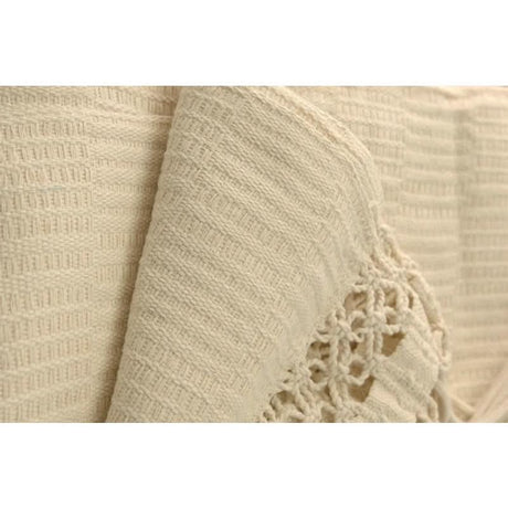 Close-up of beige fabric with a textured pattern and floral lace detail.